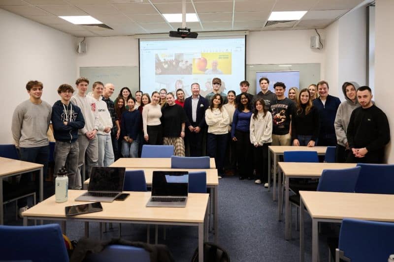 UNYP Sports Management students posing with lecturer Mike Köppe at the front of a classroom during a project briefing